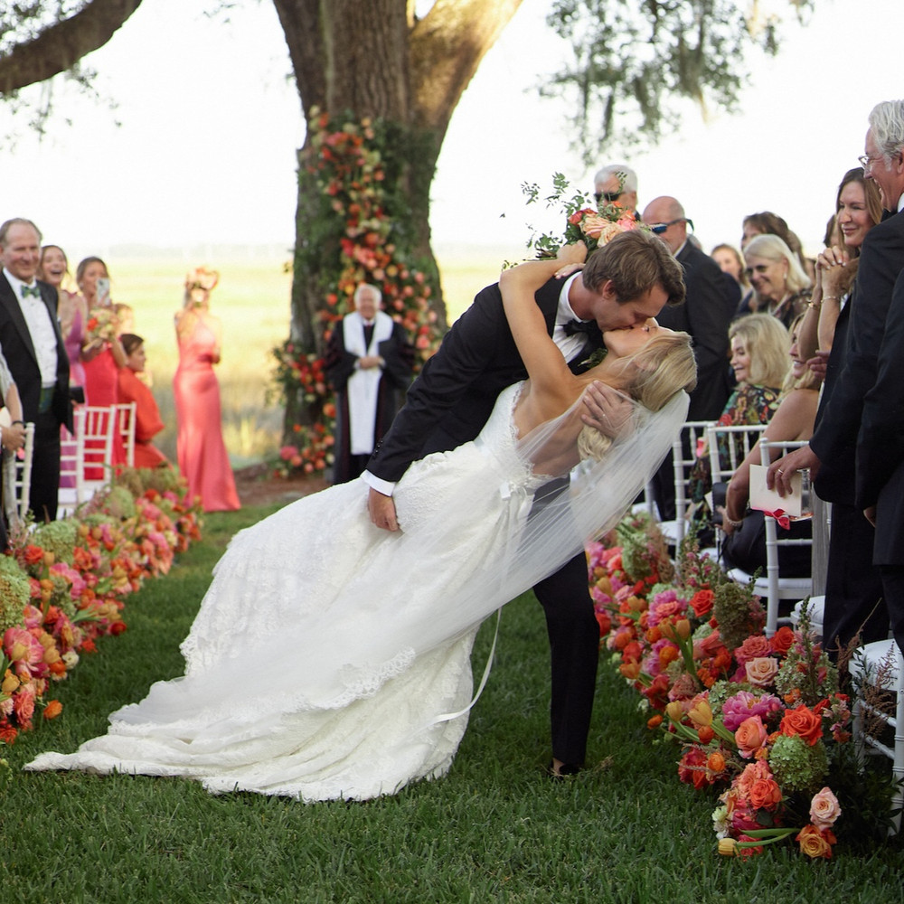 Marsh-front ceremony beneath the sailcloth tent